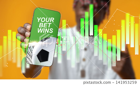 Placing a sports bet with a winning message on a smartphone during a game analysis Placing a sports bet with a winning message on a smartphone during a game analysis 141953259