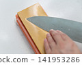 A woman's hands sharpening a knife 141953286