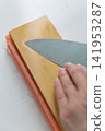 A woman's hands sharpening a knife 141953287