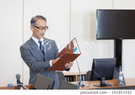 Portrait of a Japanese lawyer reviewing documents in court. Portrait of a Japanese lawyer reviewing documents in court. 141953342