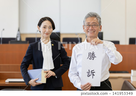 客戶和女律師在法庭上舉著勝訴證書。 客戶和女律師在法庭上舉著勝訴證書。 141953349