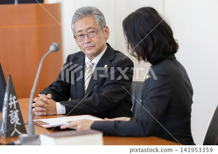 A male and female lawyer meeting in court A male and female lawyer meeting in court 141953359
