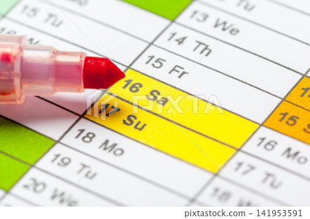 Marking saturday and sunday on a calendar with a red marker 141953591
