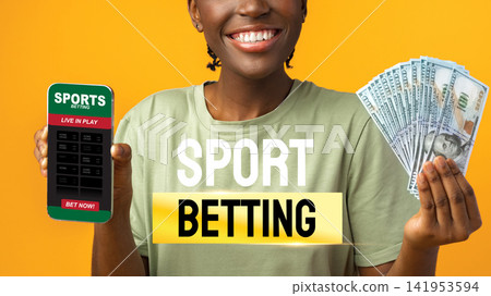 Person holds a sports betting app on a phone with cash in hand against a yellow background Person holds a sports betting app on a phone with cash in hand against a yellow background 141953594