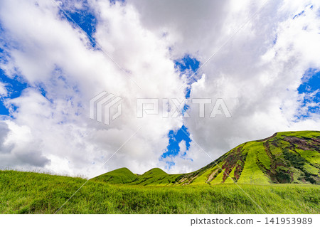 The volcanic hills of Aso shine beneath the white clouds. The volcanic hills of Aso shine beneath the white clouds. 141953989