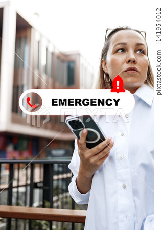 Woman holding a phone while receiving an emergency alert in an urban setting during the day Woman holding a phone while receiving an emergency alert in an urban setting during the day 141954012