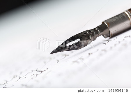 Writing on parchment paper with vintage calligraphy dip pen during the day Writing on parchment paper with vintage calligraphy dip pen during the day 141954146