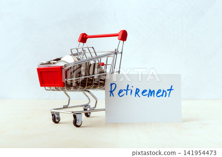 Small shopping cart filled with coins next to Retirement sign Small shopping cart filled with coins next to Retirement sign 141954473
