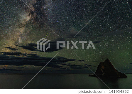 從積丹半島的真島岩上可以看到夢幻般的流星雨夜景,繁星點點的天空和柔和的綠色氛圍籠罩著它。 從積丹半島的真島岩上可以看到夢幻般的流星雨夜景,繁星點點的天空和柔和的綠色氛圍籠罩著它。 141954862