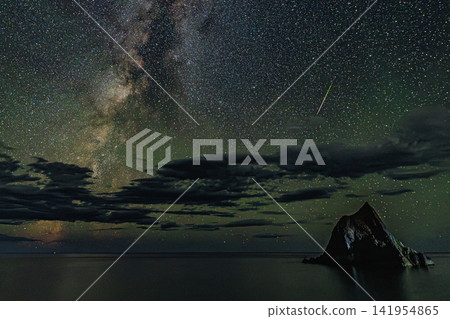 The miraculous sight of countless stars twinkling and vivid shooting stars above Mado-iwa Rock in Shakotan Town, Hokkaido. The miraculous sight of countless stars twinkling and vivid shooting stars above Mado-iwa Rock in Shakotan Town, Hokkaido. 141954865