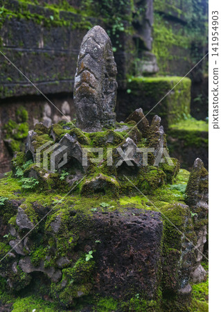 Green lush grass and moss shrouded sculpture of Buddhist pagoda at Wat Tham Pla in Northern Thailand Green lush grass and moss shrouded sculpture of Buddhist pagoda at Wat Tham Pla in Northern Thailand 141954903