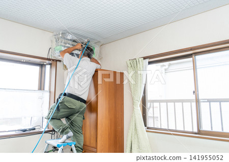 Air conditioner cleaning; a man from the air conditioner maintenance company. Air conditioner cleaning; a man from the air conditioner maintenance company. 141955052