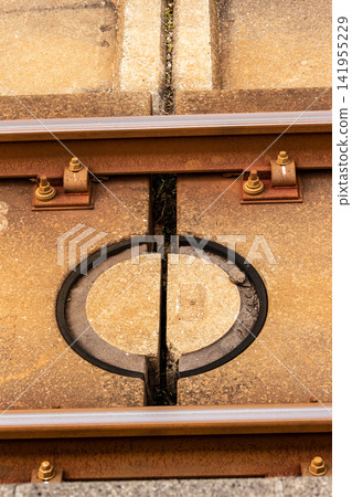 Circular protrusions on the slab track and bolted fastening points of the rail (close-up) Circular protrusions on the slab track and bolted fastening points of the rail (close-up) 141955229