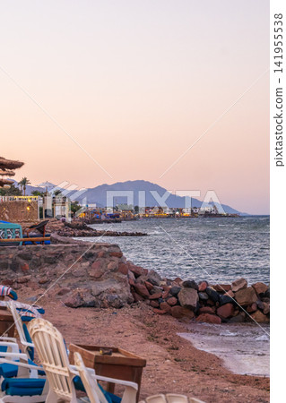 Blue waters of the Red Sea near Dahab, Egypt on the sunrise. Sinai mountains rise in the background under a clear sky. Blue waters of the Red Sea near Dahab, Egypt on the sunrise. Sinai mountains rise in the background under a clear sky. 141955538