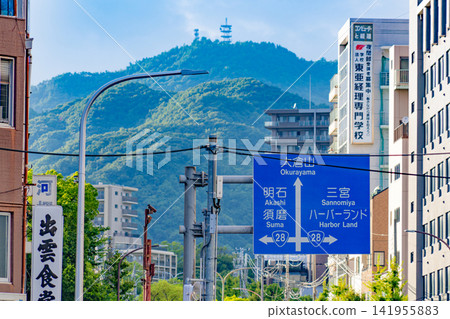 A road sign in Kobe with mountains and cityscape in the background. A road sign in Kobe with mountains and cityscape in the background. 141955883