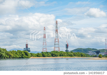 A steel tower and bridge piers for the Shin-Meishin Expressway construction project stand on the Yodogawa River embankment in Takatsuki City, Osaka Prefecture. A steel tower and bridge piers for the Shin-Meishin Expressway construction project stand on the Yodogawa River embankment in Takatsuki City, Osaka Prefecture. 141956017