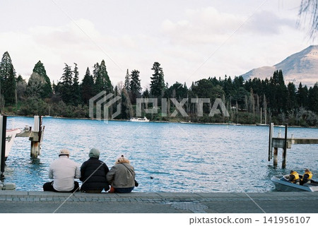 People gazing at the lakeside and mountains of Queenstown, New Zealand. People gazing at the lakeside and mountains of Queenstown, New Zealand. 141956107