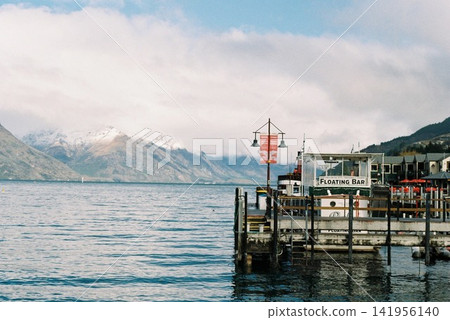 A harbor in Queenstown, New Zealand, overlooking a lake and snow-capped mountains. A harbor in Queenstown, New Zealand, overlooking a lake and snow-capped mountains. 141956140