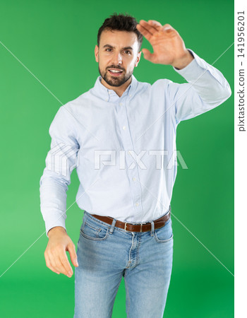 Adult man presses buttons on virtual screen and expresses various emotions. Chroma key compositing. Adult man presses buttons on virtual screen and expresses various emotions. Chroma key compositing. 141956201