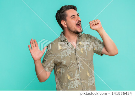 Man singing passionately into imaginary microphone expressing joy enthusiasm for musical performance Man singing passionately into imaginary microphone expressing joy enthusiasm for musical performance 141956434
