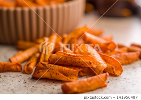 Crispy Seasoned Potato Fries With Spicy Paprika Coating On Kitchen Counter Crispy Seasoned Potato Fries With Spicy Paprika Coating On Kitchen Counter 141956497