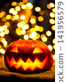 Vertical portrait of a scary Halloween jack o lantern glowing at night 141956579