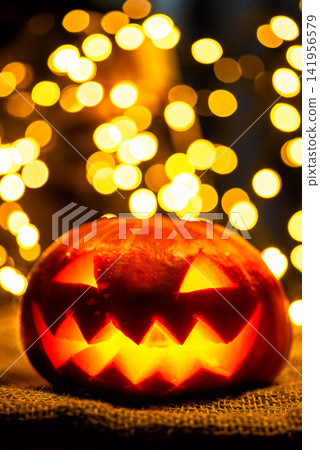 Vertical portrait of a scary Halloween jack o lantern glowing at night Vertical portrait of a scary Halloween jack o lantern glowing at night 141956579