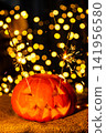 Vertical close up of a glowing Halloween pumpkin lantern in darkness 141956580