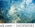 Abstract winter background texture of ice crystals freezing on blue surface 141956581