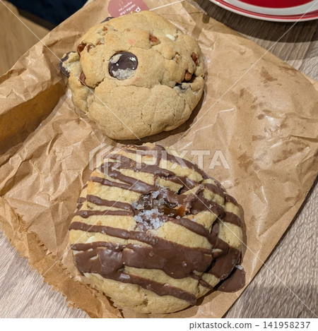 Freshly baked cookies with a golden-brown finish and chocolate chips. Perfectly crisp on the edges with a soft center, offering a delicious, comforting treat for any occasion. Freshly baked cookies with a golden-brown finish and chocolate chips. Perfectly crisp on the edges with a soft center, offering a delicious, comforting treat for any occasion. 141958237