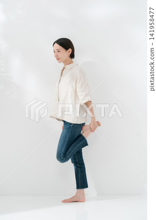 一名女子站著伸展雙腿。 一名女子站著伸展雙腿。 141958477
