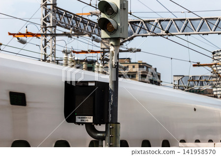 A movable gate opening/closing indicator light installed at the station and a passing Shinkansen train. A movable gate opening/closing indicator light installed at the station and a passing Shinkansen train. 141958570