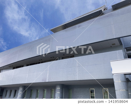 A modern tiled building exterior that stands out against the blue sky. A modern tiled building exterior that stands out against the blue sky. 141958604