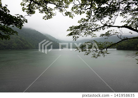 Mist-shrouded mountain ranges and a fantastical lake Mist-shrouded mountain ranges and a fantastical lake 141958635