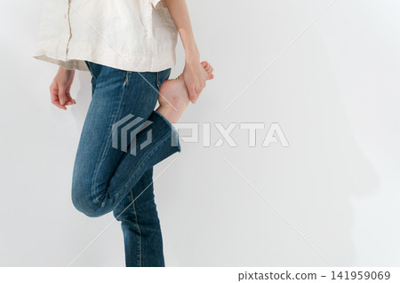 一名女子站著伸展雙腿。 一名女子站著伸展雙腿。 141959069