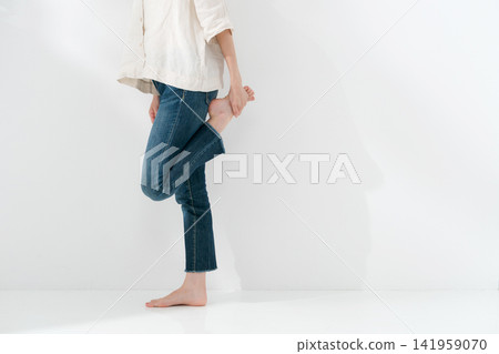一名女子站著伸展雙腿。 一名女子站著伸展雙腿。 141959070