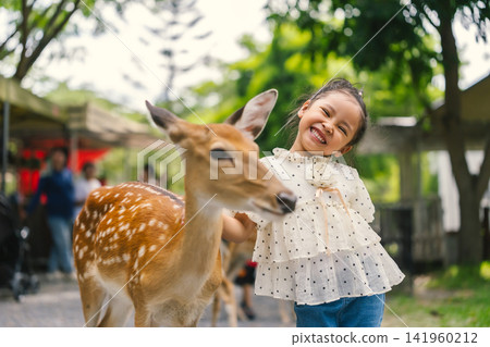 happy preschool child girl smiling and a deer 141960212