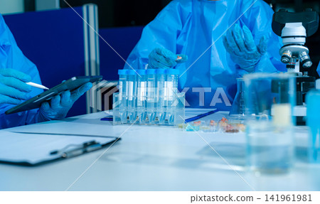 Microbiologists and nutrition experts analyze molecular samples in advanced food science labs. Microbiologists and nutrition experts analyze molecular samples in advanced food science labs. 141961981