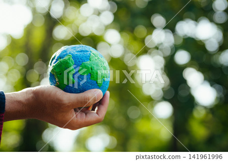 Earth in nature's time in hands with energy resource icon. Earth day. Energy saving concept. 141961996
