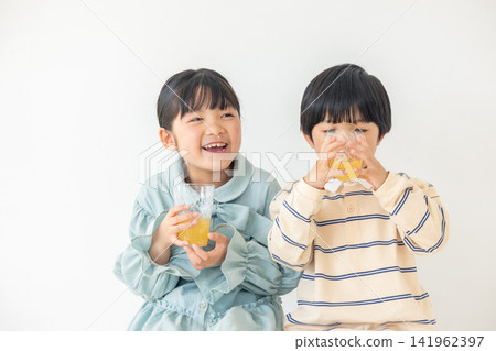 孩子們面帶笑容，愉快地享用柳橙汁。 141962397