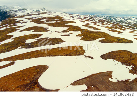 Aerial view of snow-covered mountain in summer. High mountain road Bjorgavegen. Aurlandsvegen, Aurland, Norway Aerial view of snow-covered mountain in summer. High mountain road Bjorgavegen. Aurlandsvegen, Aurland, Norway 141962488