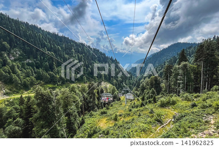 Chairlift carrying passengers through the Caucasus mountain forest at Rosa Khutor, Sochi, Russia Chairlift carrying passengers through the Caucasus mountain forest at Rosa Khutor, Sochi, Russia 141962825