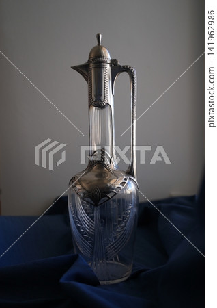 Vintage Silver and Glass Carafe on Blue Fabric Vintage Silver and Glass Carafe on Blue Fabric 141962986