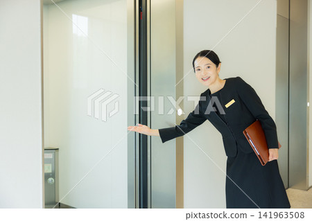 A woman guiding people to the elevator 141963508