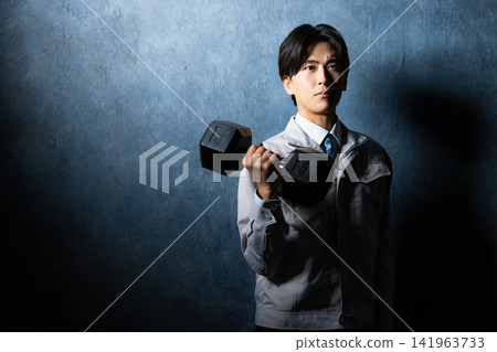 一名身穿工作服的男子正在運動。 一名身穿工作服的男子正在運動。 141963733
