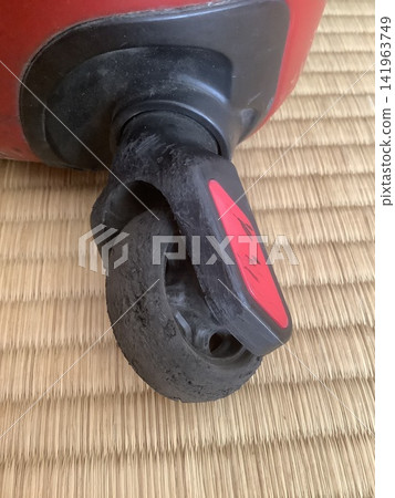 The rubber tires on the suitcase have deteriorated and broken. The rubber tires on the suitcase have deteriorated and broken. 141963749