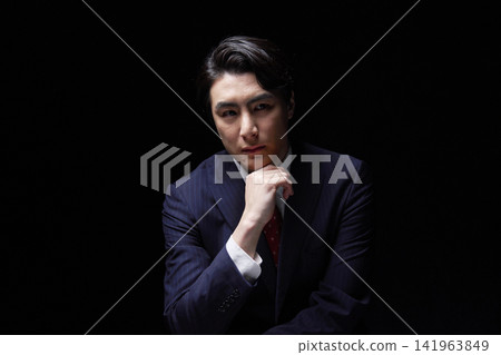 A businessman thinking in the dark A businessman thinking in the dark 141963849