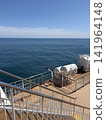 A ship's deck overlooking the blue sky and the sea. 141964148