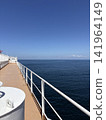 A ship's deck overlooking the blue sky and the sea. 141964149