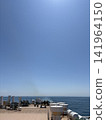 A ship's deck overlooking the blue sky and the sea. 141964150